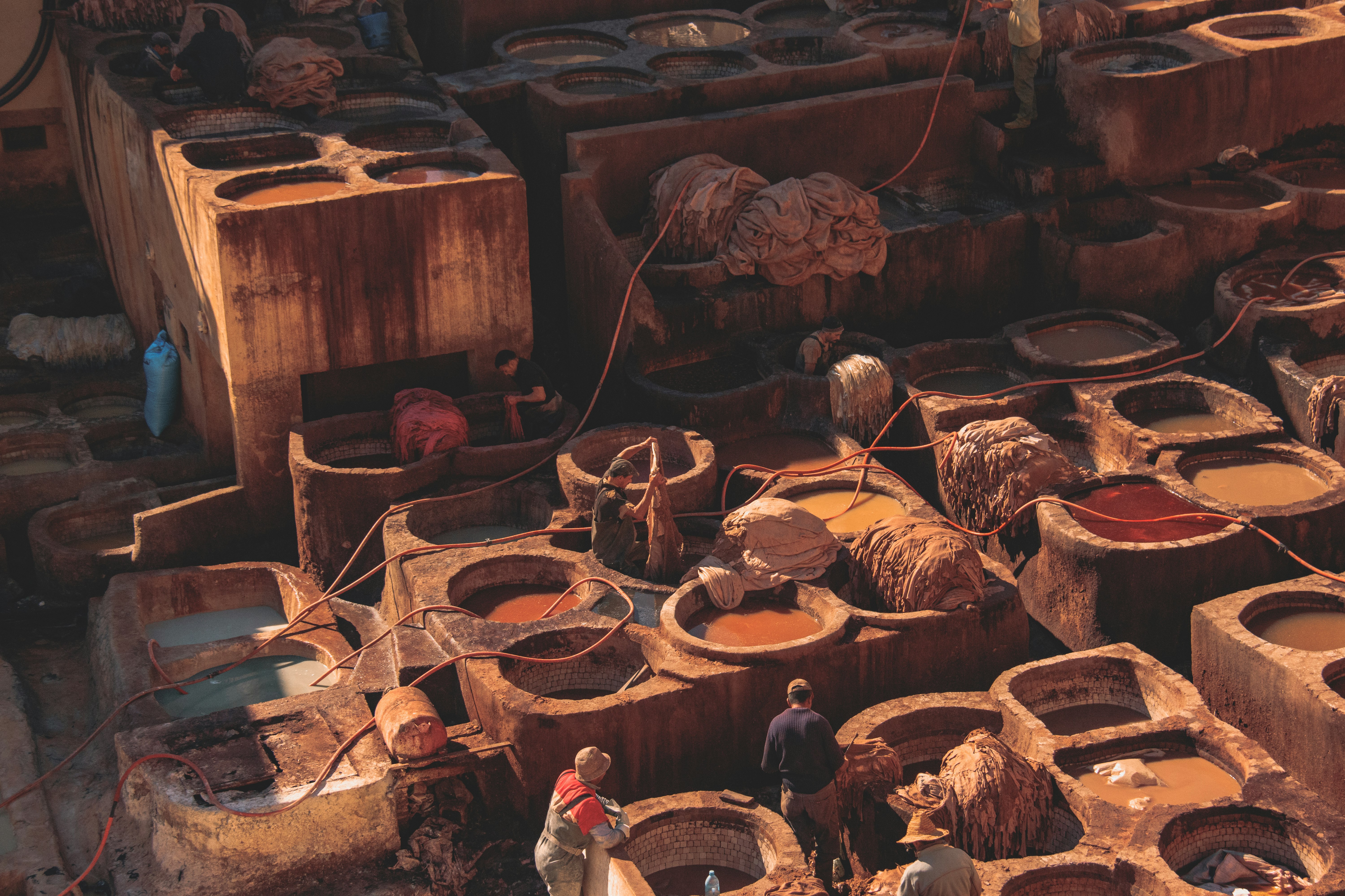 man in brown jacket standing near brown wooden barrels